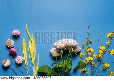 Various Flowers On The Blue Flat Lay Background With Copy Space.