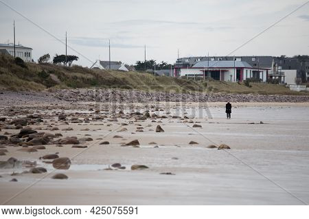 Deserted Sandy Beach In Winter Plurien France Brittany With Lonely Elderly Walking