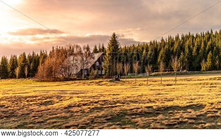 Rural Grassland Landscape In Sunny Spring Evening. Sunset In Jizerka Village With Old Wooden Hut, Ji