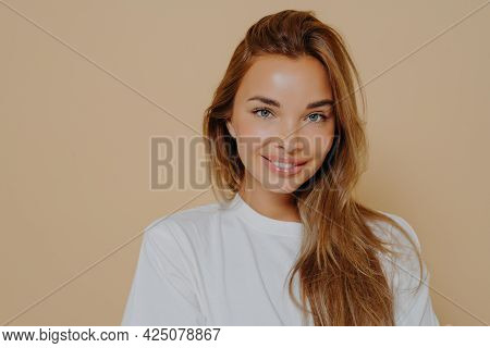 Portrait Of Beautiful Female With Long Light Brown Straight Hair Gently Smiling On Camera Wearing Ca