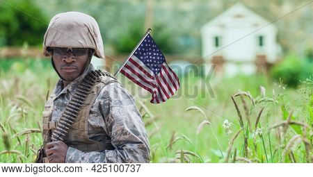 Composition of male soldier with waving american flag, against rural setting. patriotism, independence and military concept digitally generated image.