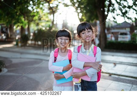 Smiling Two Young Little Girl Student Holding Book