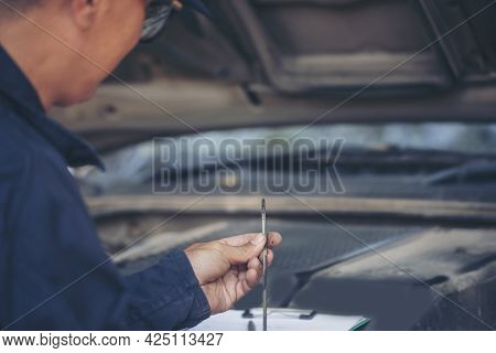 Car Mechanic Man Hand Checking Dipstick Engine Oil Car Mechanical On Site Service. Close Up Hand Man