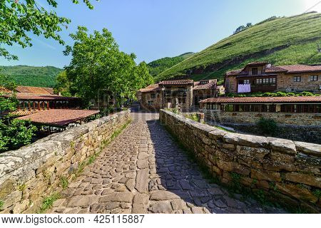 Ancient Stone Bridge Crossing A River In Medieval Village. Barcena Mayor Santander.
