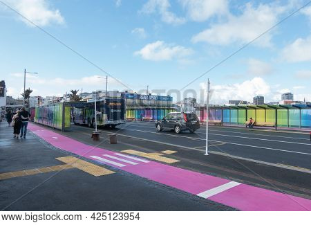 Auckland New Zealand - June 19 2021; Pink Cycle Lane On Footpath Between Bus Stop And Glass Wall Wit