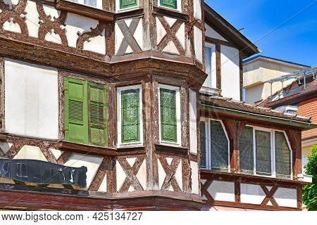 Oriel And Windows With Green Shutters Of Old European Style Half Timbered Frame House