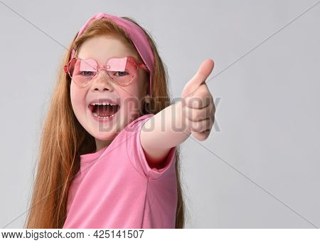 Loudly Laughing Red-haired Girl Child Wearing Stylish Sunglasses And Summer Fashion Outfit Gesturing