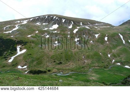 Beautiful scenic view in a rainy and cloudy day over the Transalpina road, the highest mountain road in the Carpathians located in the Parang mountains, Romania, Europe