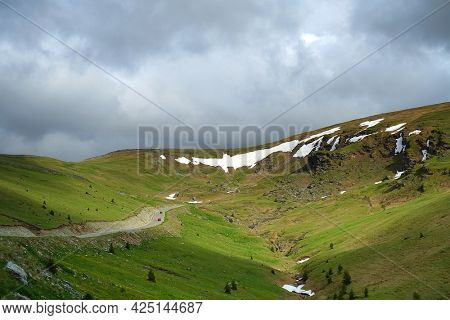 Beautiful scenic view in a rainy and cloudy day over the Transalpina road, the highest mountain road in the Carpathians located in the Parang mountains, Romania, Europe