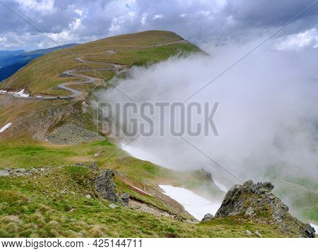 Beautiful scenic view in a rainy and cloudy day over the Transalpina road, the highest mountain road in the Carpathians located in the Parang mountains, Romania, Europe