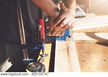 Entrepreneur Woodwork Holding A Tacker To Assemble The Wood Pieces As The Customer Ordered.