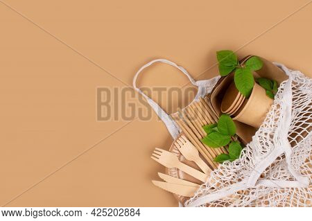Kraft Paper Food Cups, Plates And Containers With Wooden Cutlery In White Cotton Net Bag On Brown Ba