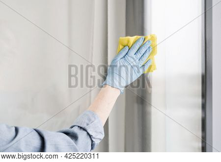 Woman With Rubber Glove Wiping Window. High Quality Beautiful Photo Concept
