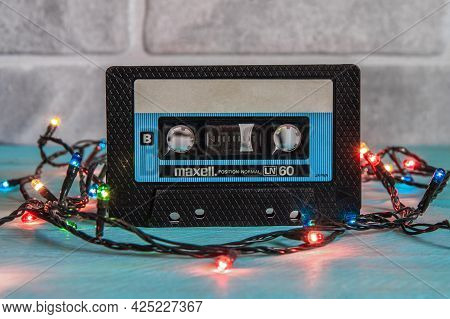 Krasnodar, Russia - March 11, 2021: A Black Maxell Audio Cassette Stands On A Blue Wooden Background