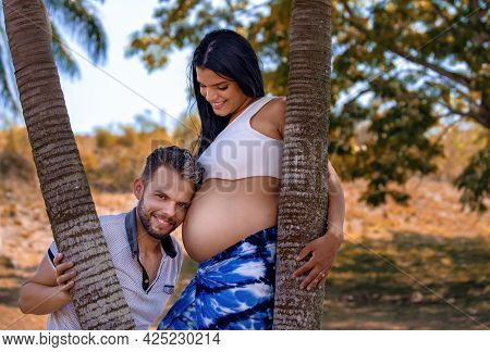 Photo Of A Young Couple. The Man's Head Is Resting On The Belly Of The Pregnant Woman