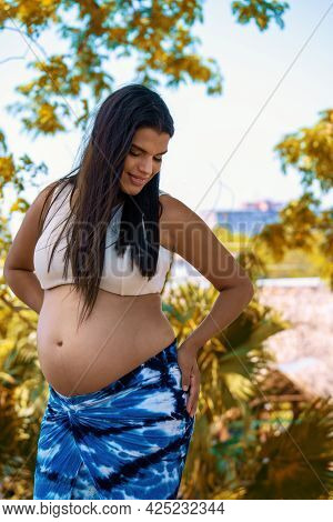 Outdoor Photo Of A Young Pregnant Woman With Long Hair