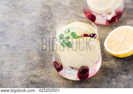 Summer Refreshing Cold Cocktail With Lemon, Lemon Balm And Cherry - Hard Seltzer In A Glass On The T