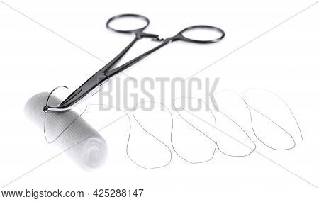 Forceps With Suture Thread And Bandage Roll On White Background. Medical Equipment