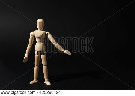 Wooden Human Model On Black Background, Space For Text. Mini Mannequin