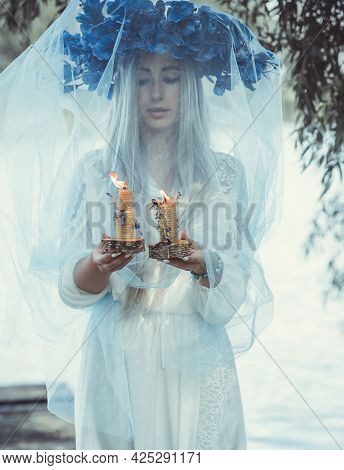 Beautiful Girl In Wreath Of Flowers In Forest. Portrait Of Young Beautiful Woman Wearing White Bride