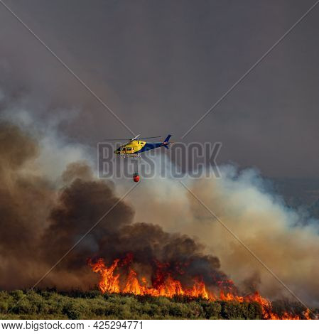 Helicopter With Bambi Bucket Over The Flames