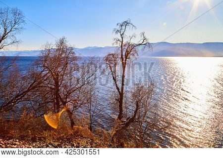 Circum Baikal Railway Running Along The Shore Of Lake Baikal On An Autumn Sunny Day With A Yellow La