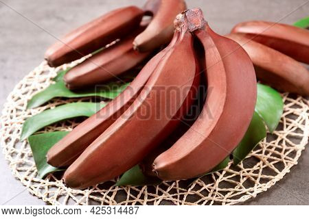 Tasty Red Baby Bananas On Grey Table, Closeup