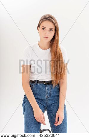 Portrait Of Young Attractive Caucasian Woman With Long Hair In T-shirt And Blue Jeans Isolated On Wh
