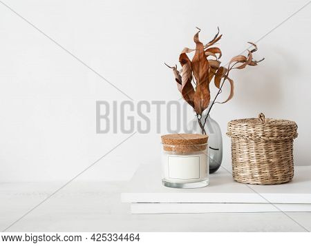 Cozy Autumn Home Still Life Of Dry Fall Branches In Vase, White Glass Candle, Wicker Box And Magazin