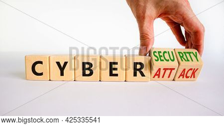 Cyber-security Vs Cyber-attack Symbol. Businessman Turns Wooden Cubes, Changes Words Cyber-attack To