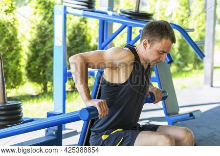 Young Man Doing In Workout In The Gym On Nature. Guy Athlete, Push Up, Pumping Up Muscles. Healthy L