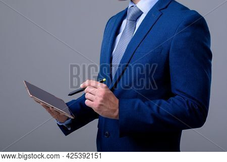 Midsection of caucasian businessman using digital tablet, isolated on grey background. business technology, communication and growth concept.