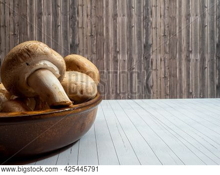 Mushrooms In A Ceramic Cup On A Wooden Background Close Up.