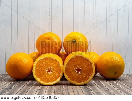 Oranges Whole And Sliced On Wooden Background. Healthy Lifestyle Concept.