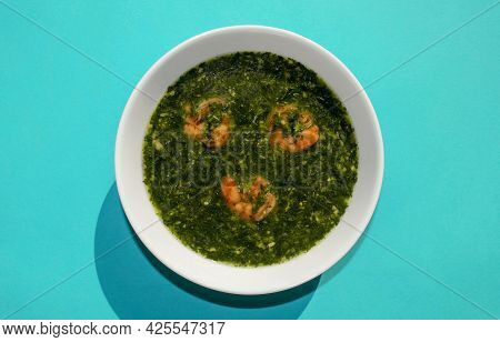 Famous Traditional Arabic Cuisine. Molokhia Green Soup With Shrimps On Blue Background. Flat Lay, To