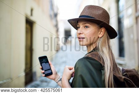 Young Woman Traveler In City On Holiday Using Smartphone, Sightseeing.