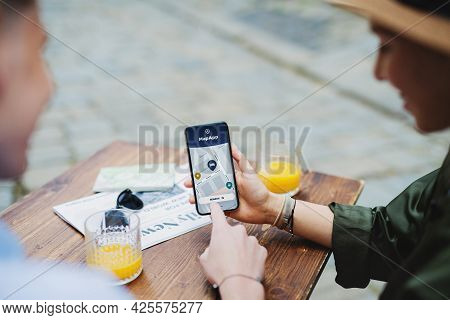 Unrecognizable Couple Travelers With Smartphone Looking Fat Digital Map In City On Holiday.