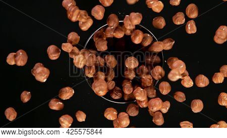 Rotating Raw Hazelnuts on Black Background. Top Shot.