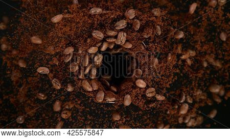 Rotating Coffee Beans in coffee grinder, Black Background.