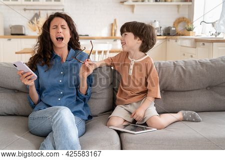 Exhausted Mummy Helpless Scream Stressed With Disobedient Preschool Son Distracting Her From Surfing