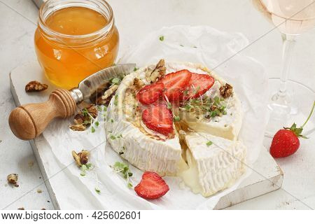Camembert With Strawberries, Nuts And Honey On A White Plate