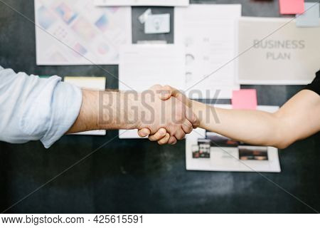 Happy c olleagues holding hands in the office