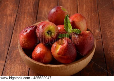 Nectarine. Ripe Juicy Organic Nectarines  In A Wooden Bowl. Whole And Sliced Fruit On A Wooden Table
