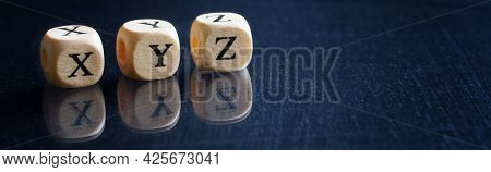 Three Last Letters Of The English Alphabet X, Y, Z On Wooden Cubes. Reflective Denim-like Surface. W