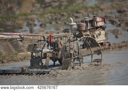 Close-up Of Muddy Machine Ploughing Rice By Traditional Methods In Ricefields Phongsali, Laos