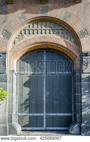 Medieval Style European Wooden Gate From An Arch Doorway. Ornate Exterior Brick Works With Classic C