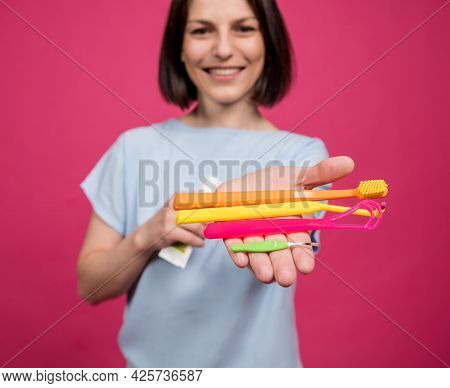 Beautiful Young Woman Uses An Oral Care Kit Consisting Of A Tongue Scraper, Single Tufted And Interd