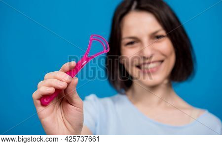 Beautiful Happy Young Woman With Tongue Scraper On Blank Blue Background