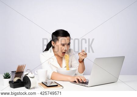 Asian Woman Working Hard Overtime Eating Instant Noodles At Office.