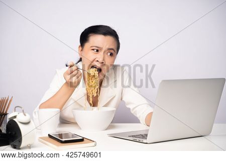 Asian Woman Working Hard Overtime Eating Instant Noodles At Office.